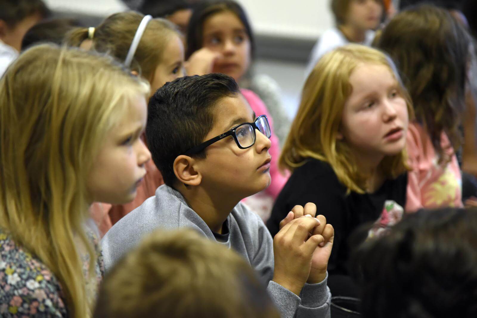 Fokus på skoleelever der lytter intenst og kigger på Ask