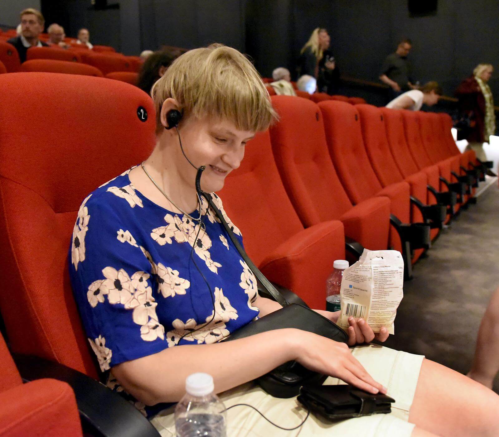 Portræt af Anja der sidder i biografsæde med høretelefoner