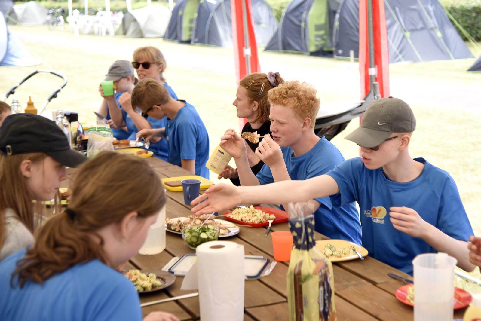 Et hold af eleverne sidder under en pavillon og spiser frokost