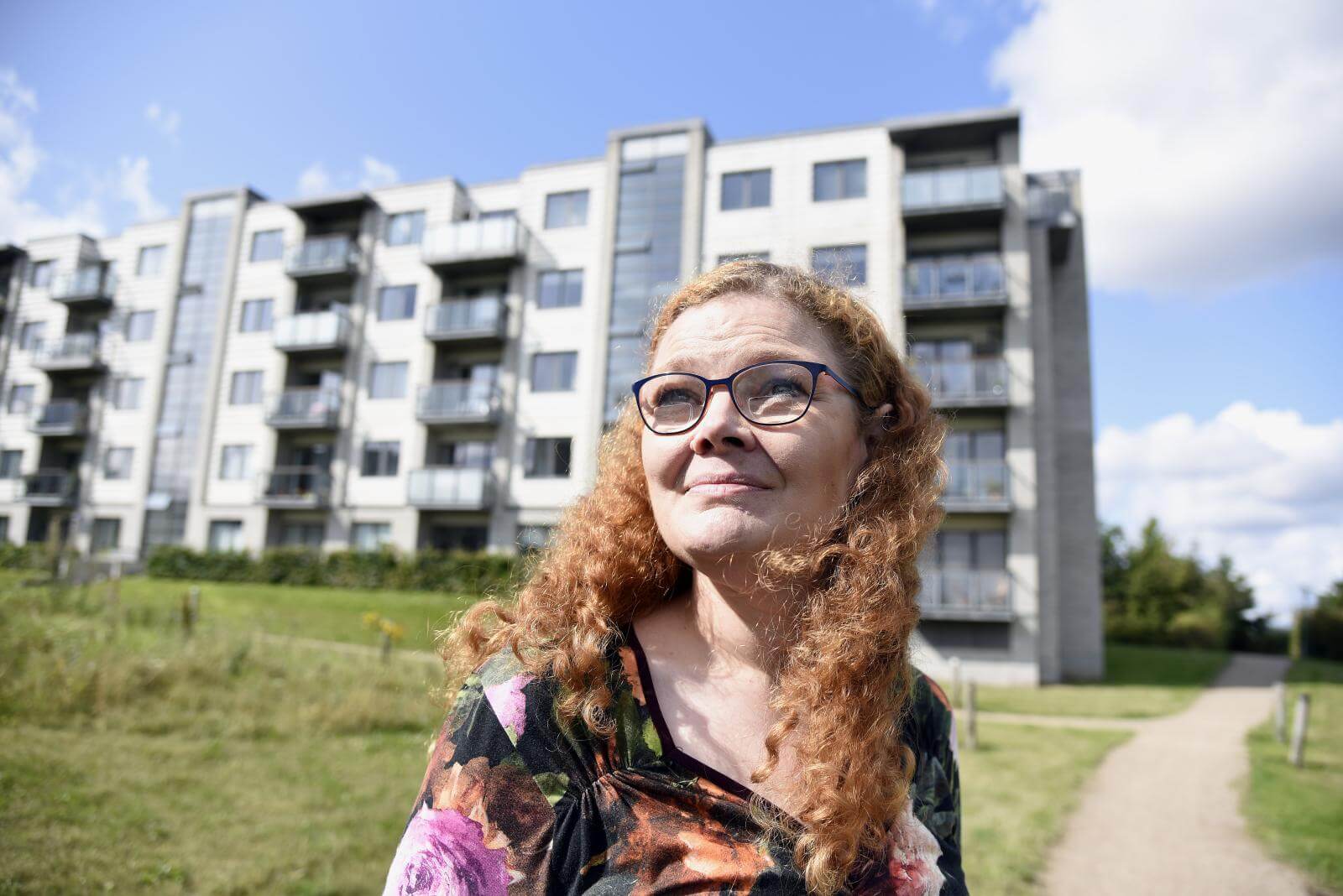 Stinna står udenfor højhuse og kigger op mod himlen