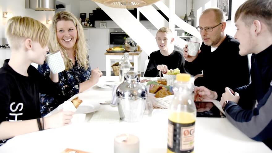 Søren sidder med sin kone og tre børn rundt om køkkenbordet og spiser morgenmad
