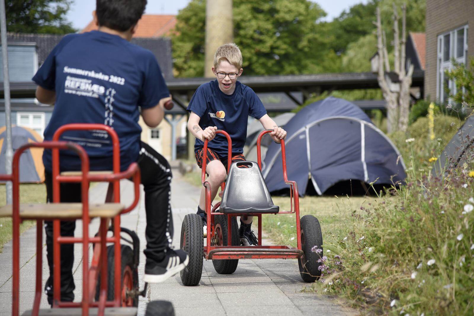 To yngre drenge kører på gocart imod hinanden