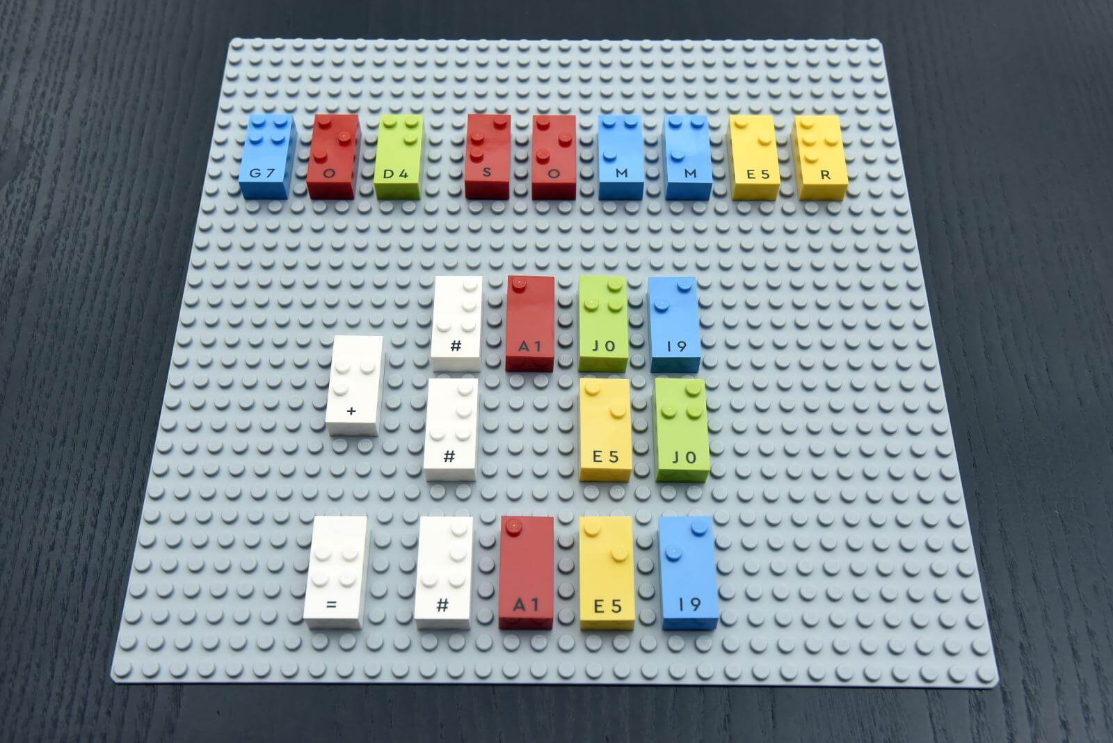 Grå Lego plade hvor der står god sommer med Lego Braille Bricks