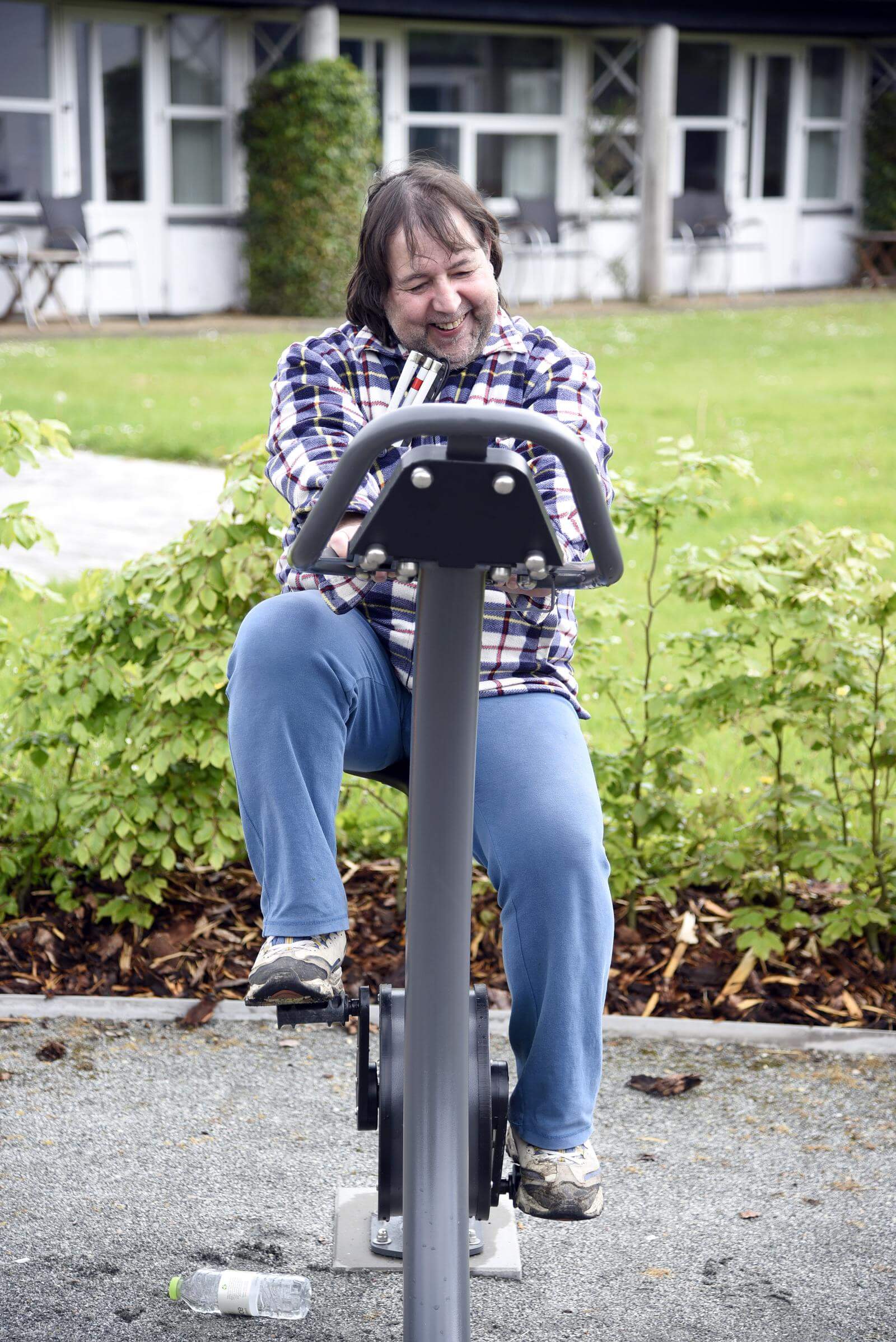 Dennis tramper i pedalerne på en motionscykel udenfor