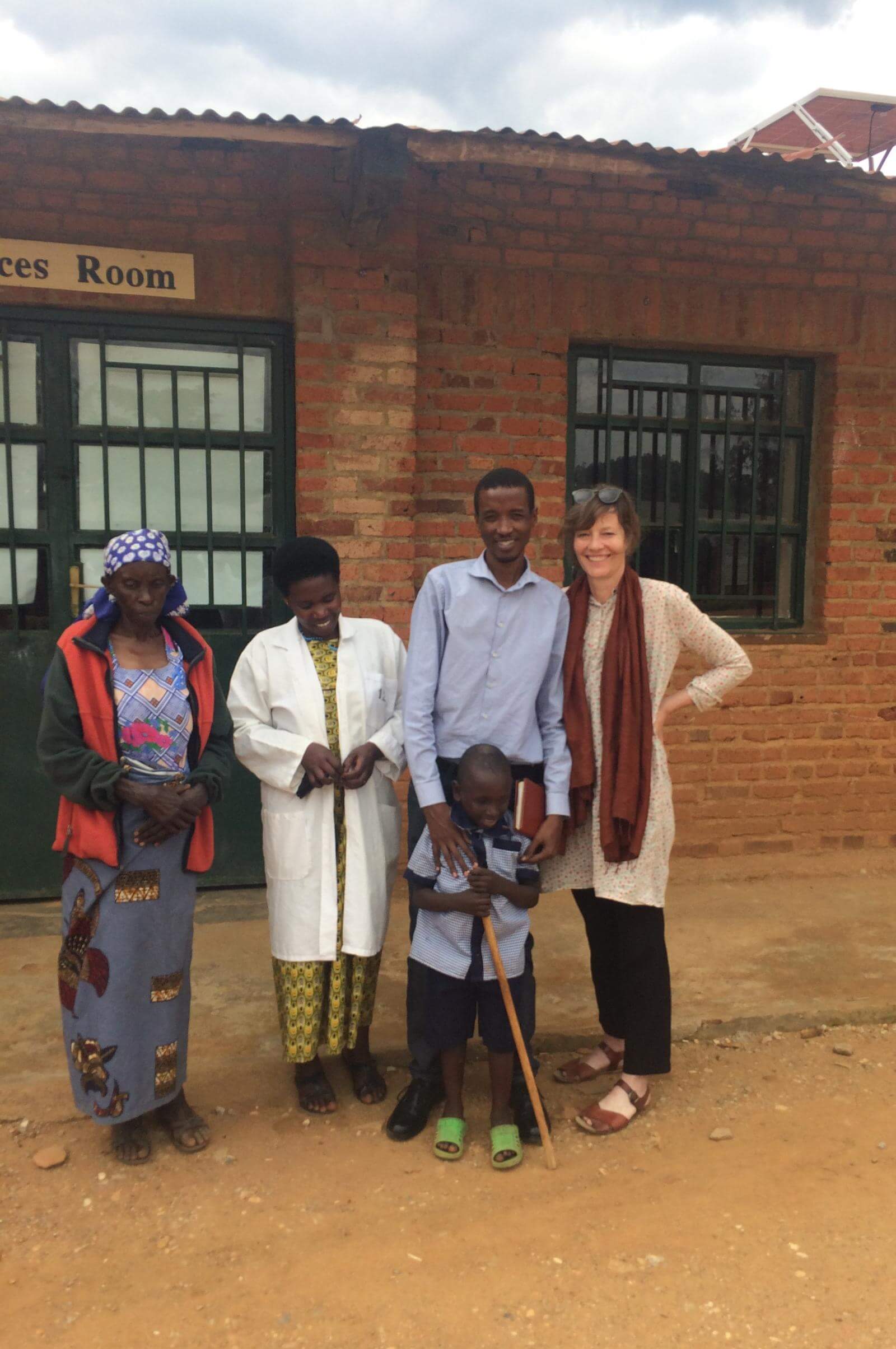 Susanne på skolebesøg i Rwanda omgivet af tre lokale