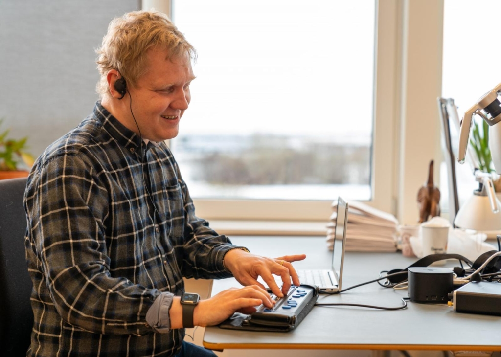 Jesper Holten læser punktskrift på sit kontor med punktdisplay