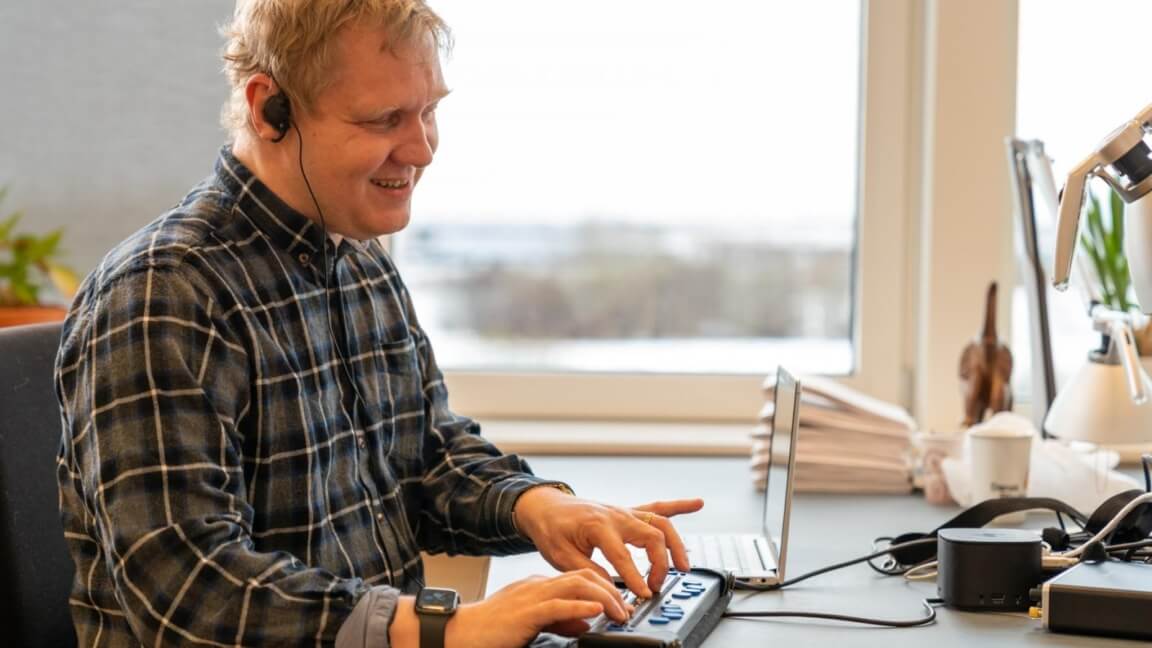 Jesper Holten læser punktskrift på sit kontor med punktdisplay