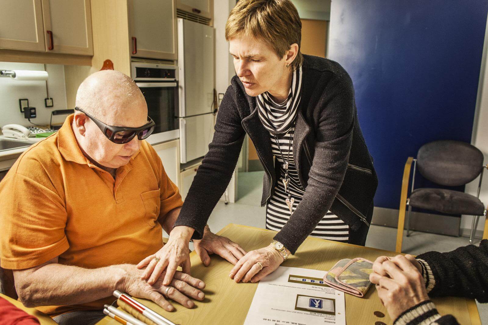 Kursusleder Anette Bjerre viser en kursist på et nyblindekursus, hvordan han kan kende forskel på mønter.