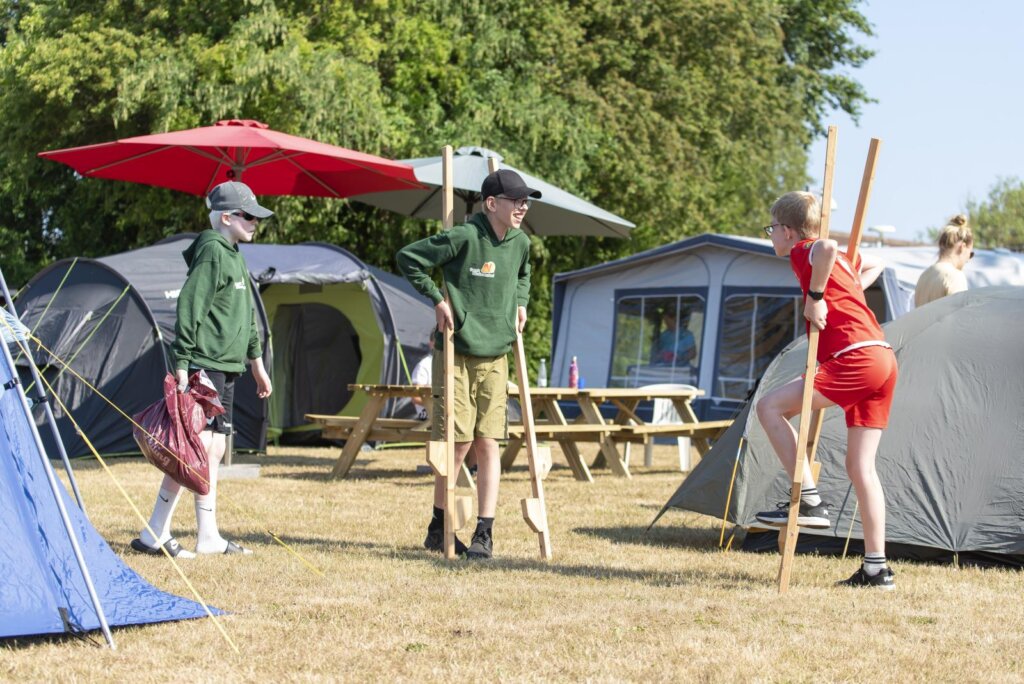 Tre børn på sommerskolen går på stylter