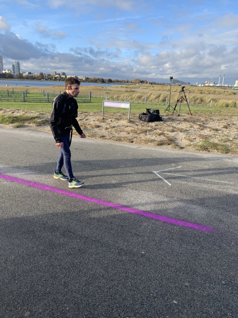 Claudio løber med høretelefoner langs en lilla streg, der er tegnet på asfalten
