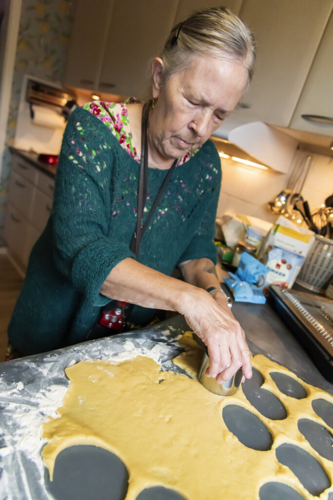 Mette er ved at udstikke runde småkager af sin dej, der er rullet tynd på køkkenbordet