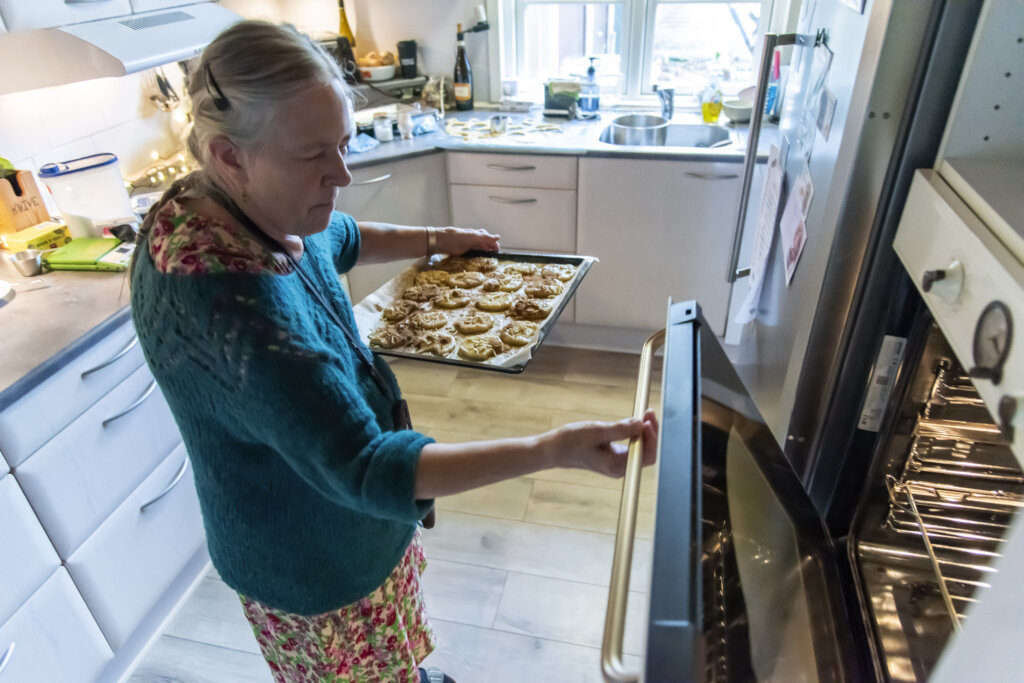 Mette er ved at sætte en bageplade med småkager ind i ovnen