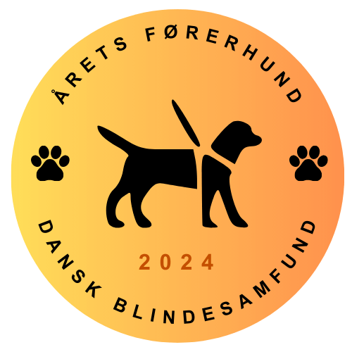 En rund badge i gule og orange farver med teksten Årets Førerhund 2024. Der er også et ikon for en førerhund samt poteaftryk.