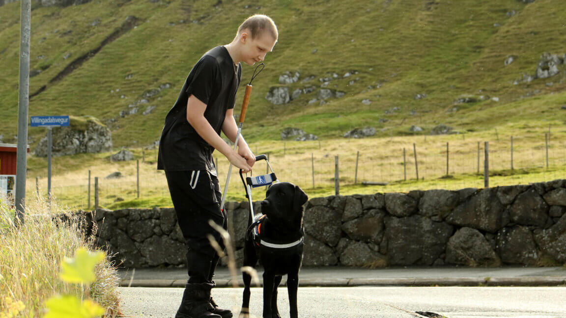 Andrias giver førerhunden Andy førerhundebøjle på uden for