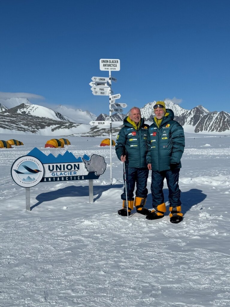 Arne og Claus står ved et skilt med teksten Union Glacier på Antarktis