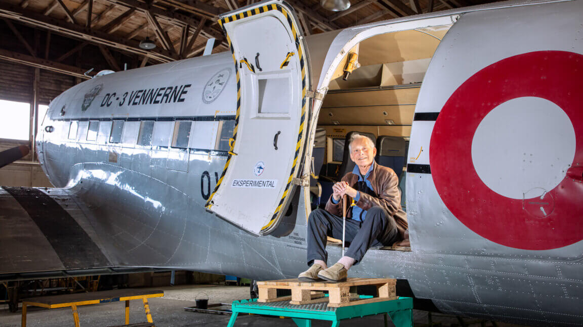 Torben sidder i døren til DC-3 og holder sin blindestok