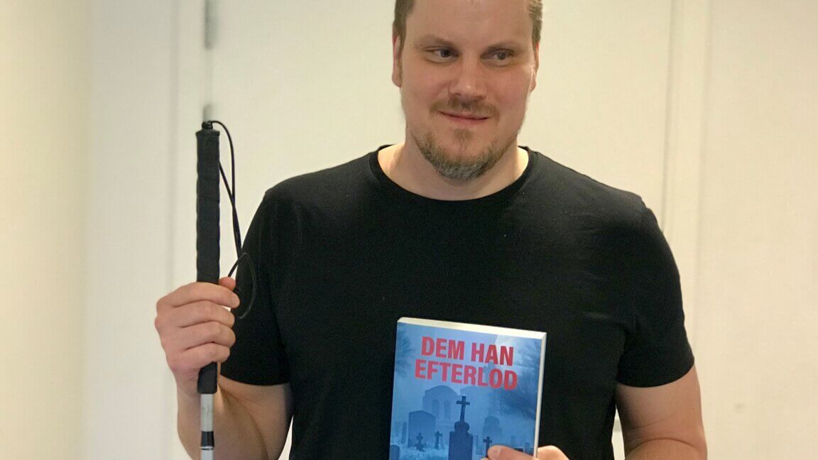 Jesper Bæksted holder sin blindestok og bogen Dem han efterlod i den anden hånd