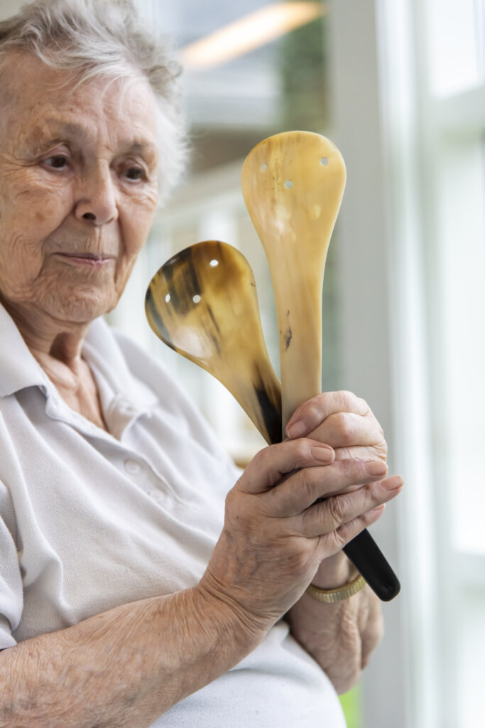 Elise fremviser sit salatbestik lavet i horn. Det skinner blankt