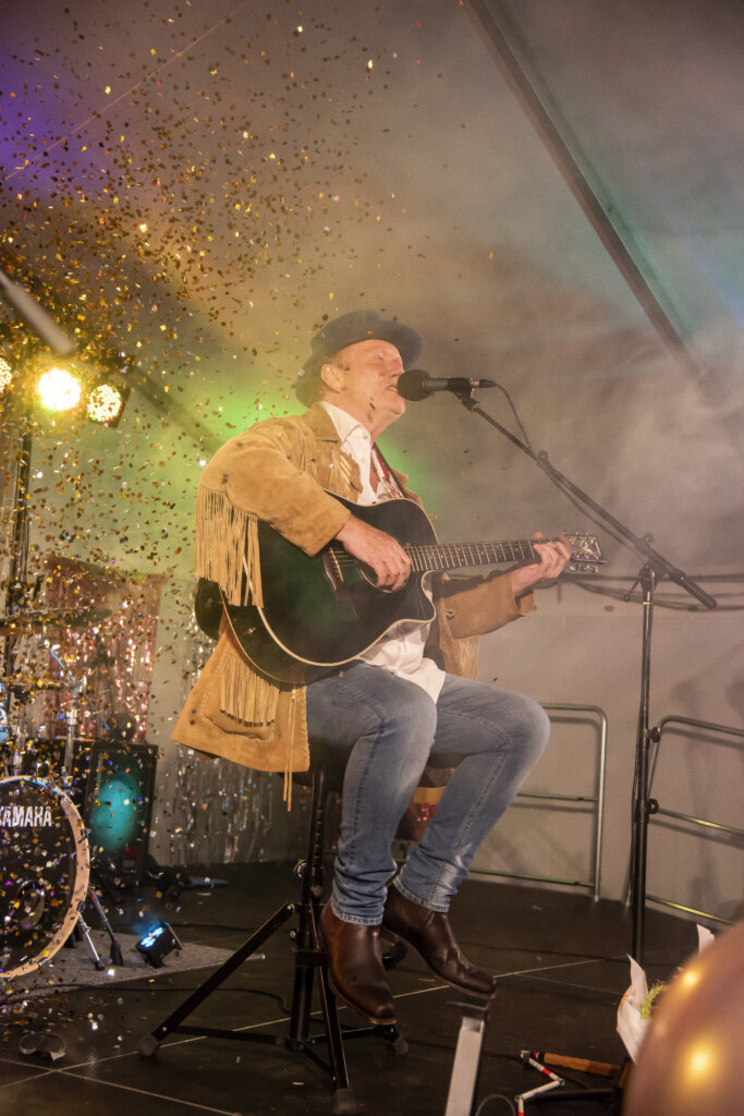 Det regner med guld konfetti over Søren Høg, som synger og spiller guitar på scenen