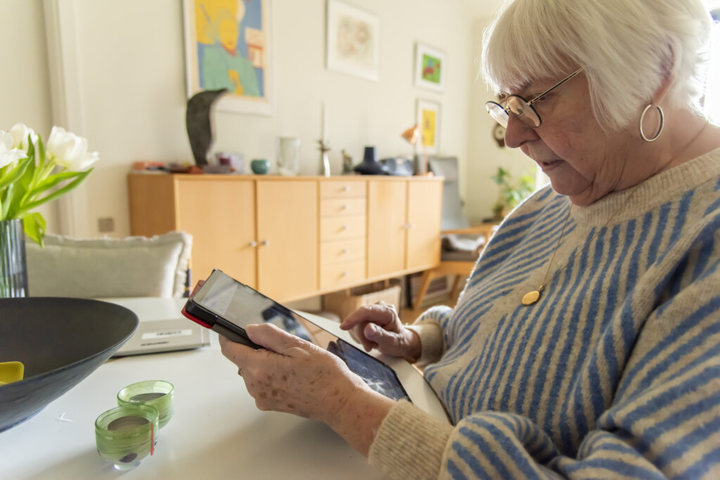 Birthe forstørrer teksten på sin iPad