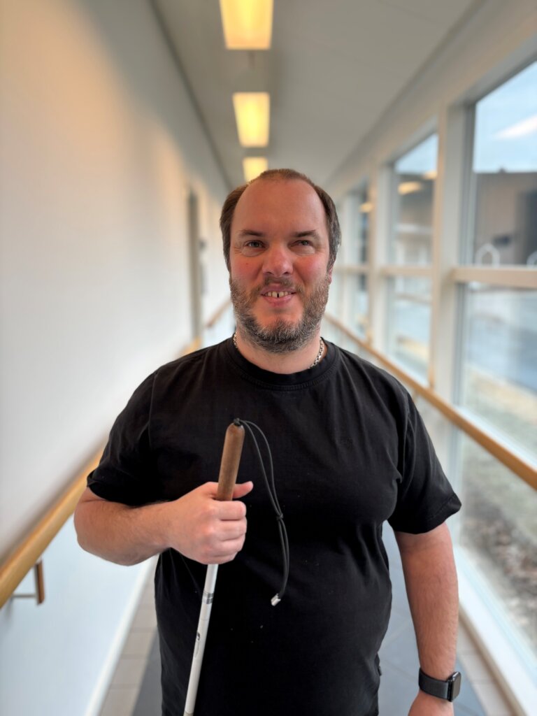 Portræt af Søren Jensen der står med sin blindestok