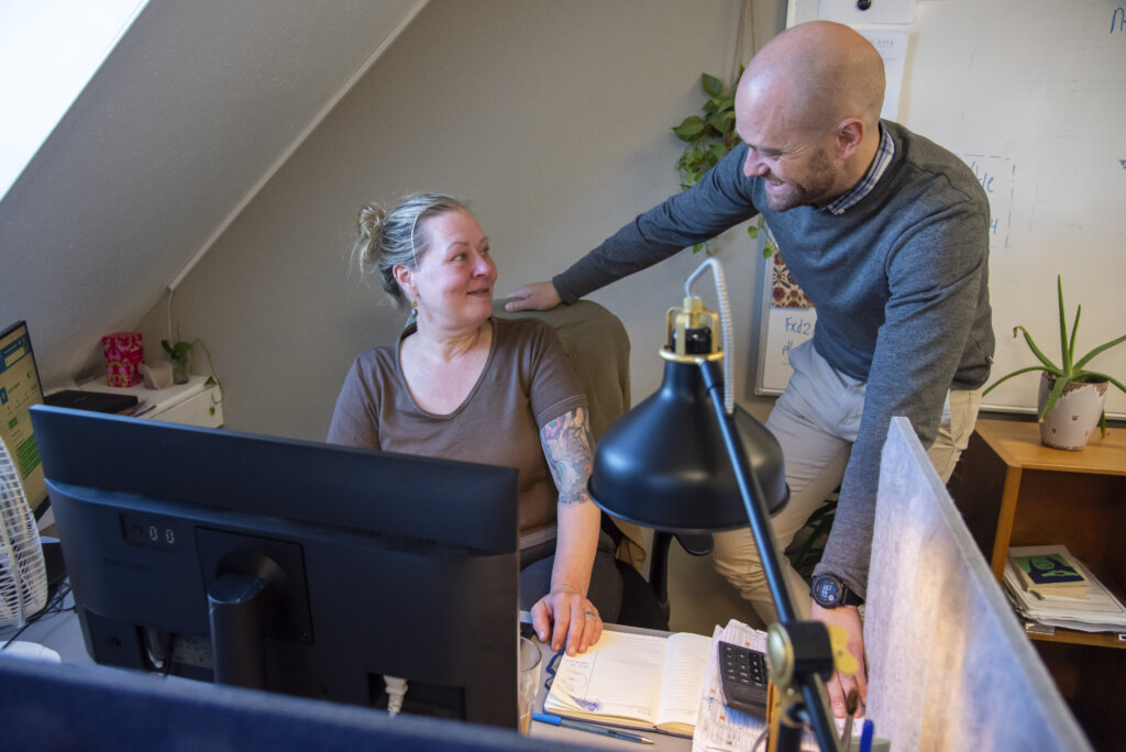 Kristoffer snakker med en kvindelig kollega p&aring; kontoret