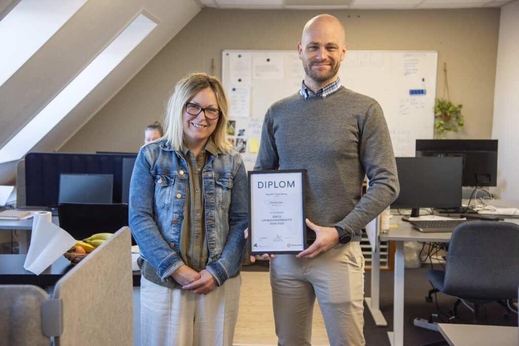 Kristoffer holder diplom for &Aring;rets Cphbusinesspraktik 2024/2025. Han st&aring;r ved siden af sin praktikvejleder Marie p&aring; kontoret