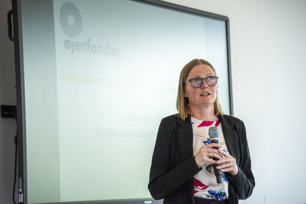 Diana byder velkommen med mikrofon i hånden