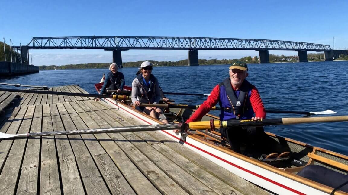 Tre roere i en havkajak på vej ud på havet