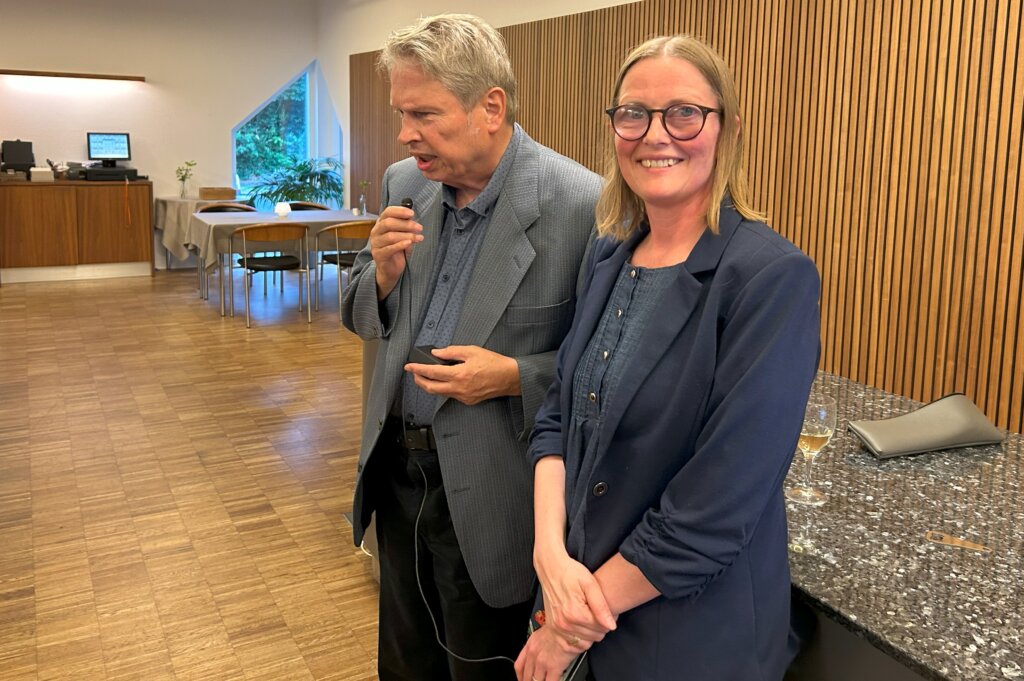 Hans holder tale i mikrofonen. Ved siden af står Diana Stentoft