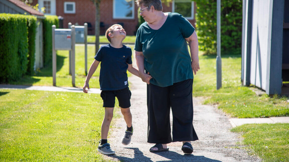 Marco hopper glad og holder sin mormor i hånden uden for. De griner til hinanden