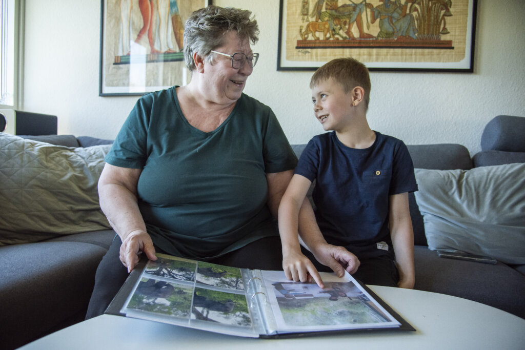 Marco og Merete kigger i billedbog fra rejsen