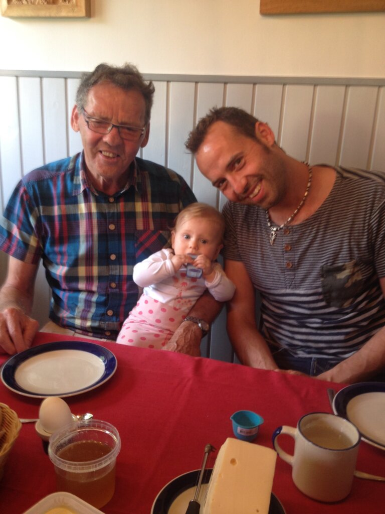 Svend sidder ved stueborden med Torben Chris ved sinde af og barnebarnet imellem dem. Hun er cirka 1 år