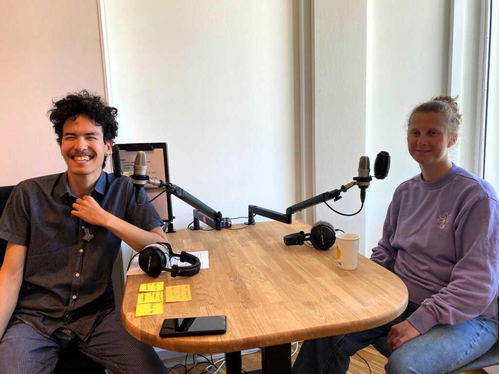 Podcastv&aelig;rt Tor sidder over for Mie Prip Henriksen ved et bord, hvor der st&aring;r to mikrofoner