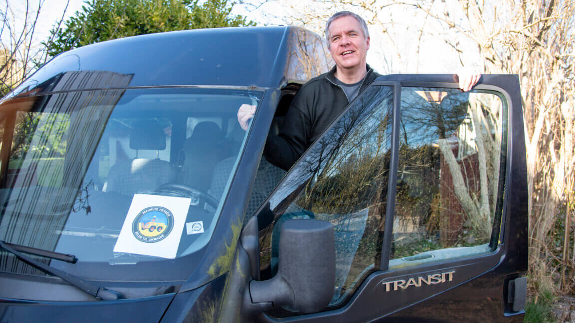 Mikael stikker hovedet ud af forsædet på en sort invalidebil