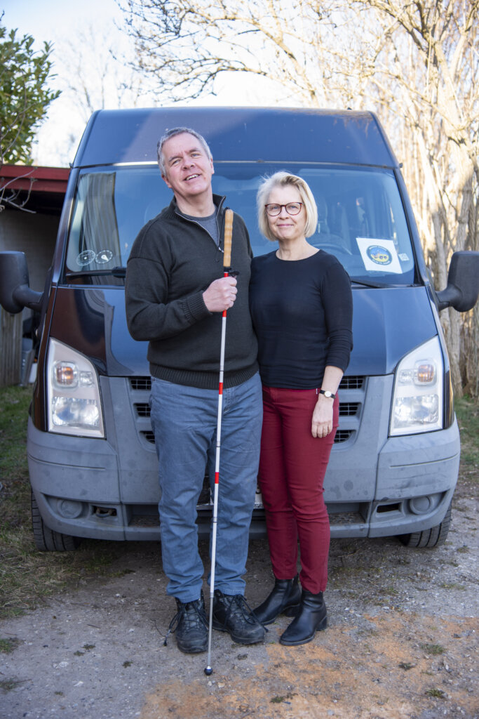 Mikael og Sofie holder om hinanden og st&aring;r foran den sorte invalidebil, de skal aflevere i Ukraine