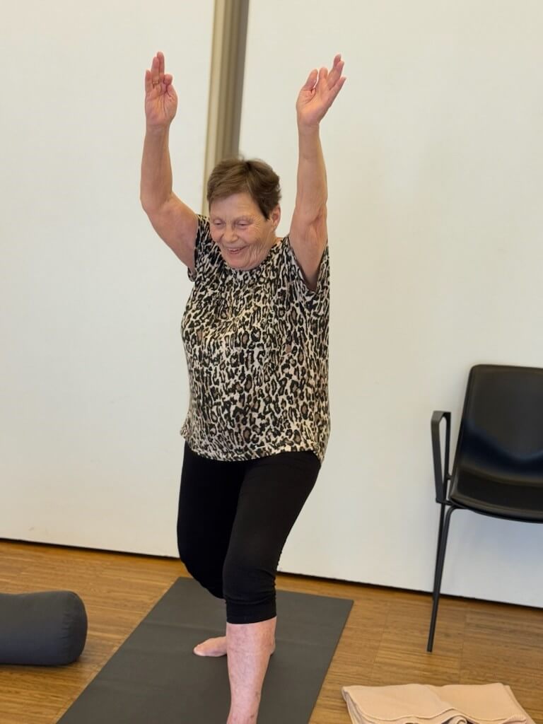 En kvindelig deltager laver solhilsen p&aring; yogam&aring;tte