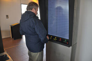 Digital buskøreplan, hvor man ved hjælp af ’knapper’ kan scrolle op og ned og få oplæst køretider for de enkelte busruter.