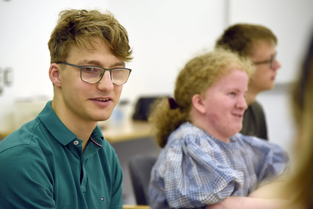 De unge kursister sidder rundt om et bord