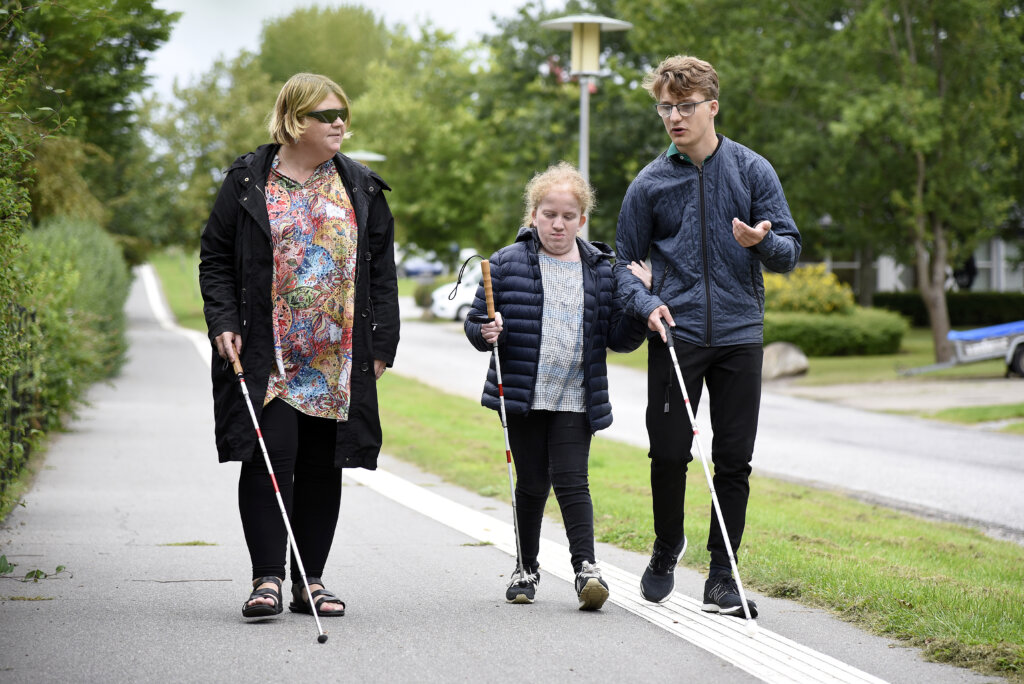 Underviser Lene går med Jonathan og Nicoline uden for. De går med hver deres blindestok