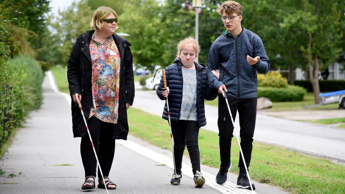 Underviser Lene går med Jonathan og Nicoline uden for. De går med hver deres blindestok