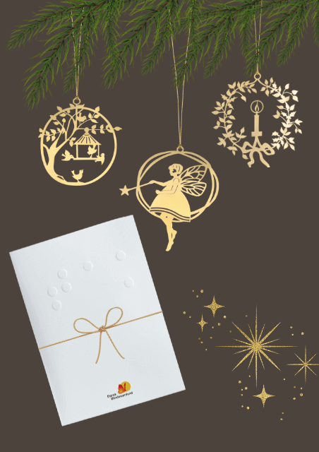 Billedet viser mandelgaven, som er 3 guld juleophæng og et brev med en sløjfe på. Julepynten hænger på et stykke gran.