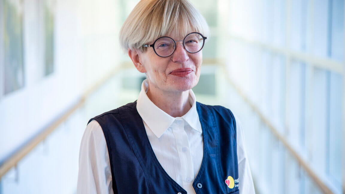 Portræt af Helle Riley med vest, hvor der er logo fra Synslinjen