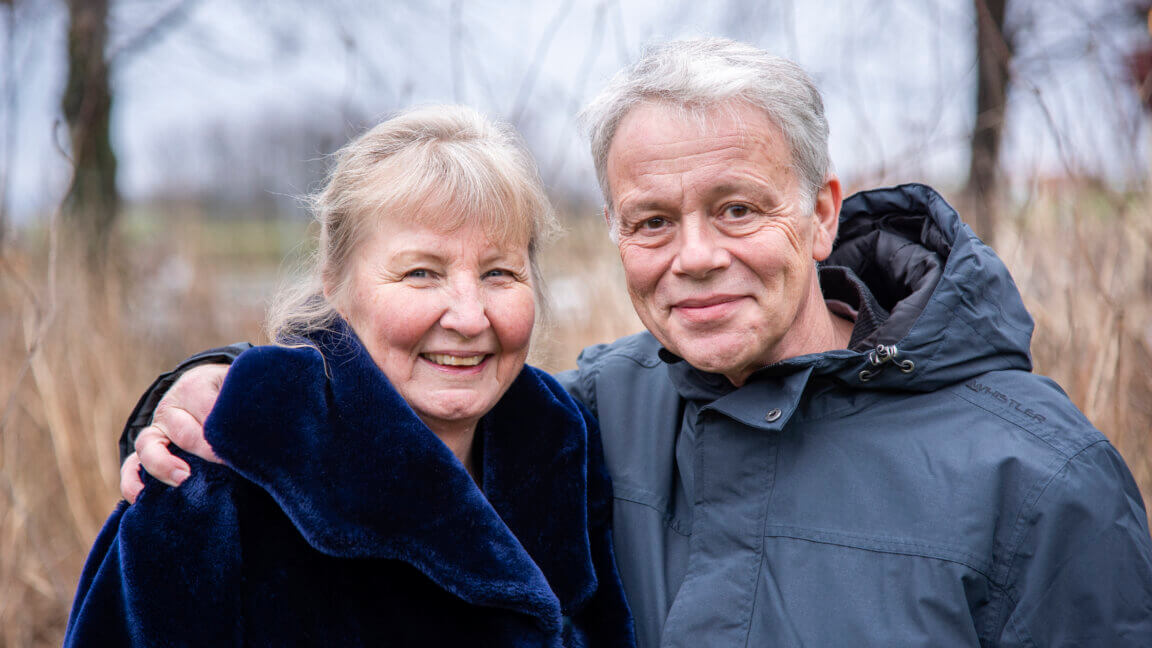 Ægteparret Helle og Henrik smiler og holder om hinanden