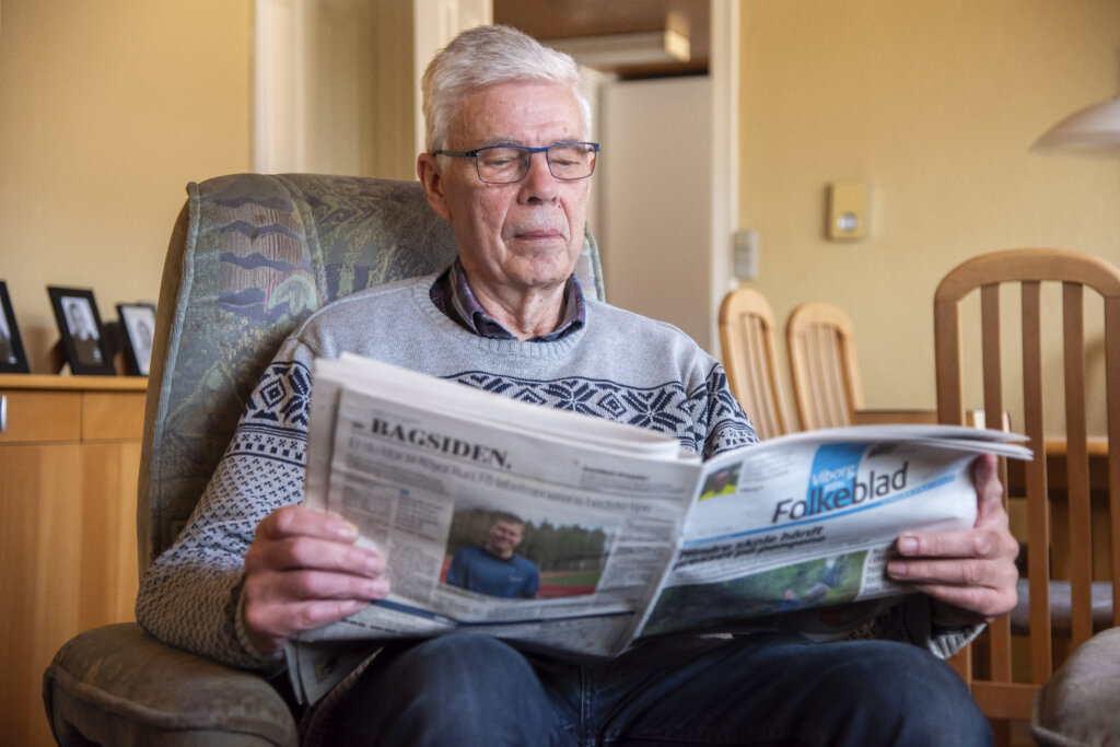Orla læser avis i sin lænestol i stuen