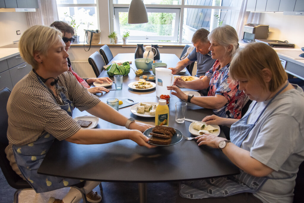 Deltagerne og underviserne sidder ved spisebordet og spiser frokost