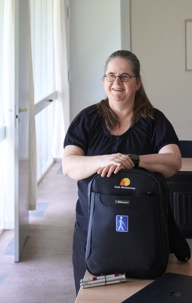 Karina holder om sin taske fra Dansk Blindesamfund, hvori hun har hjælpemidler, hun viser til nye medlemmer