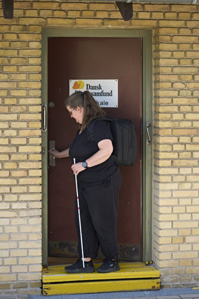 Karina åbner døren til et af Dansk Blindesamfunds lokaler i Odense