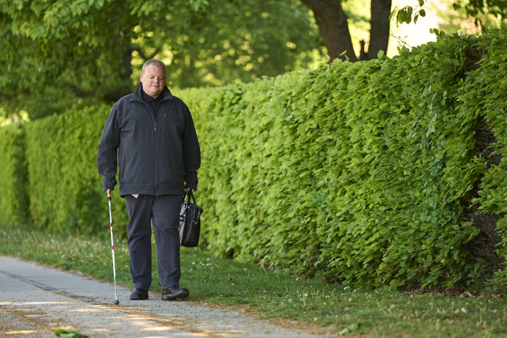 Lasse kommer gående uden for med sin blindestok