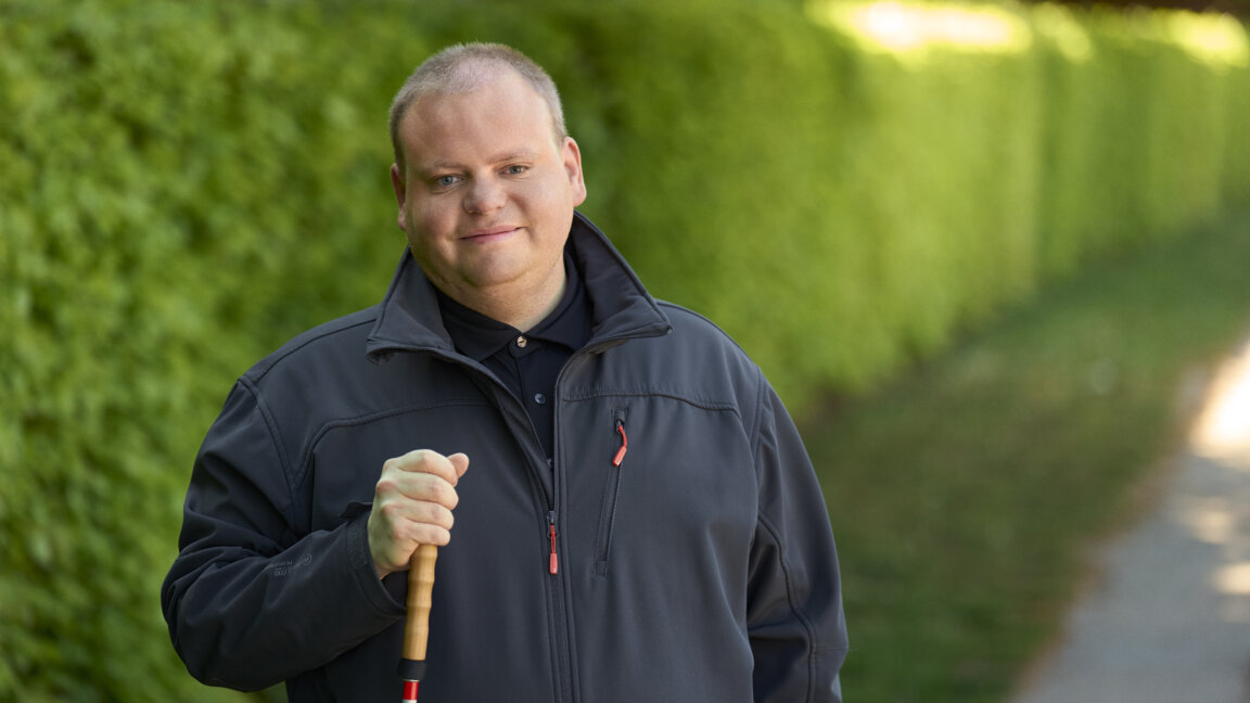 Portræt af Lasse som står med sin blindestok uden for